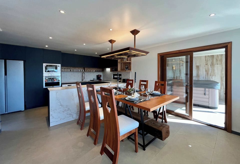 Open dining space w/ long wooden table & sliding doors to the patio