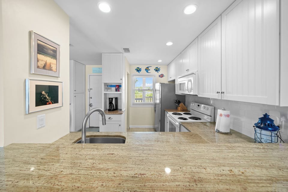 Your fully-equipped kitchen features granite countertops, white cabinets, and all the appliances you need for preparing delicious meals during your stay.