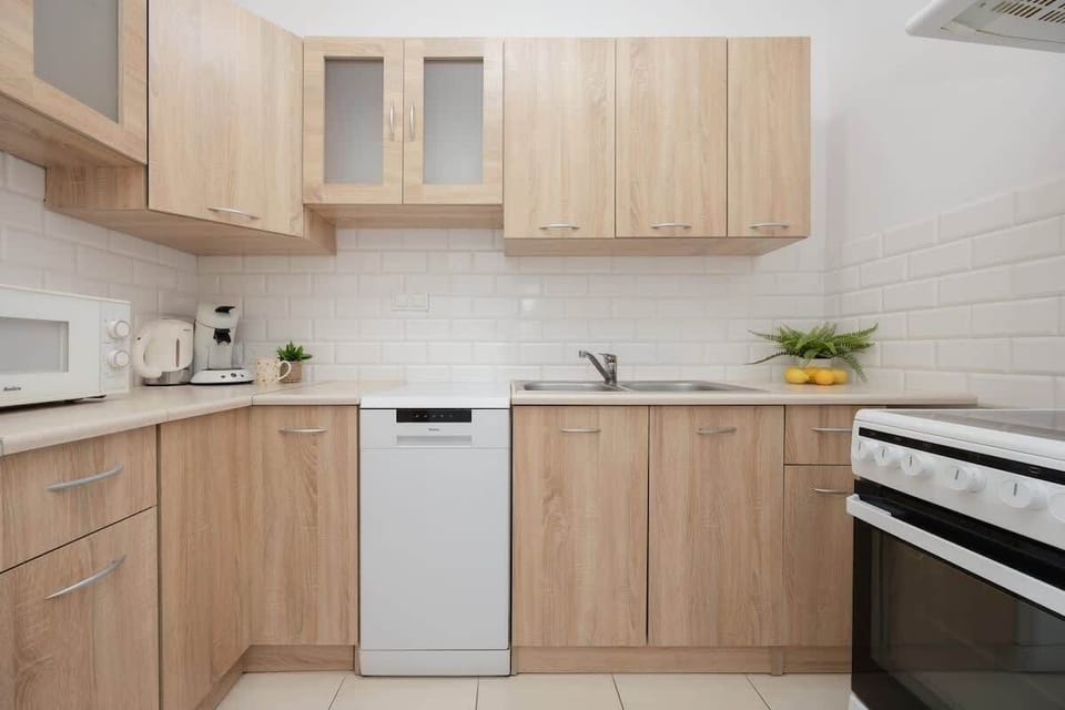 The kitchen's sleek design includes all necessary cookware and utensils. 