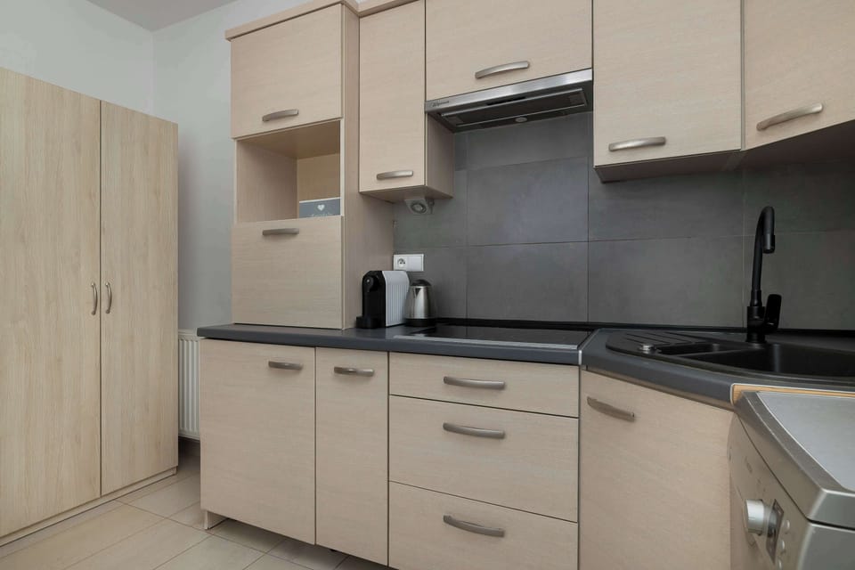 Kichen with modern design with white and grey cabinets, fully equipped.