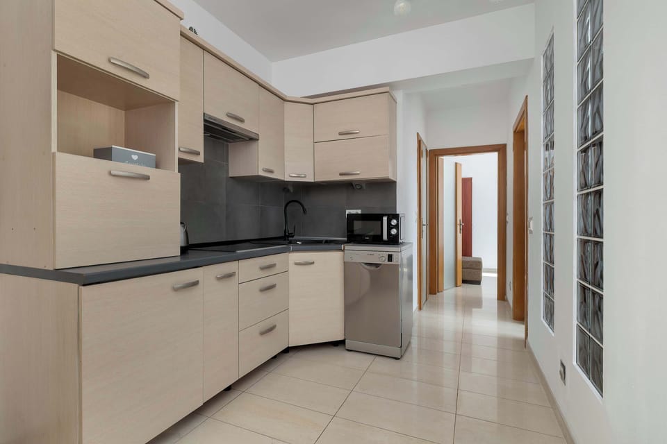 Kichen with modern design with white and grey cabinets, fully equipped.