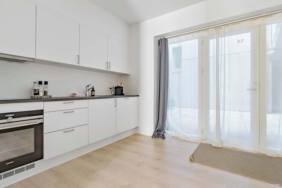 Kitchen and entrance to the apartment with double-curtains (Thin curtains and blackout curtains). The entrance-area outside is fully private and can only be accessed by residents of the property.