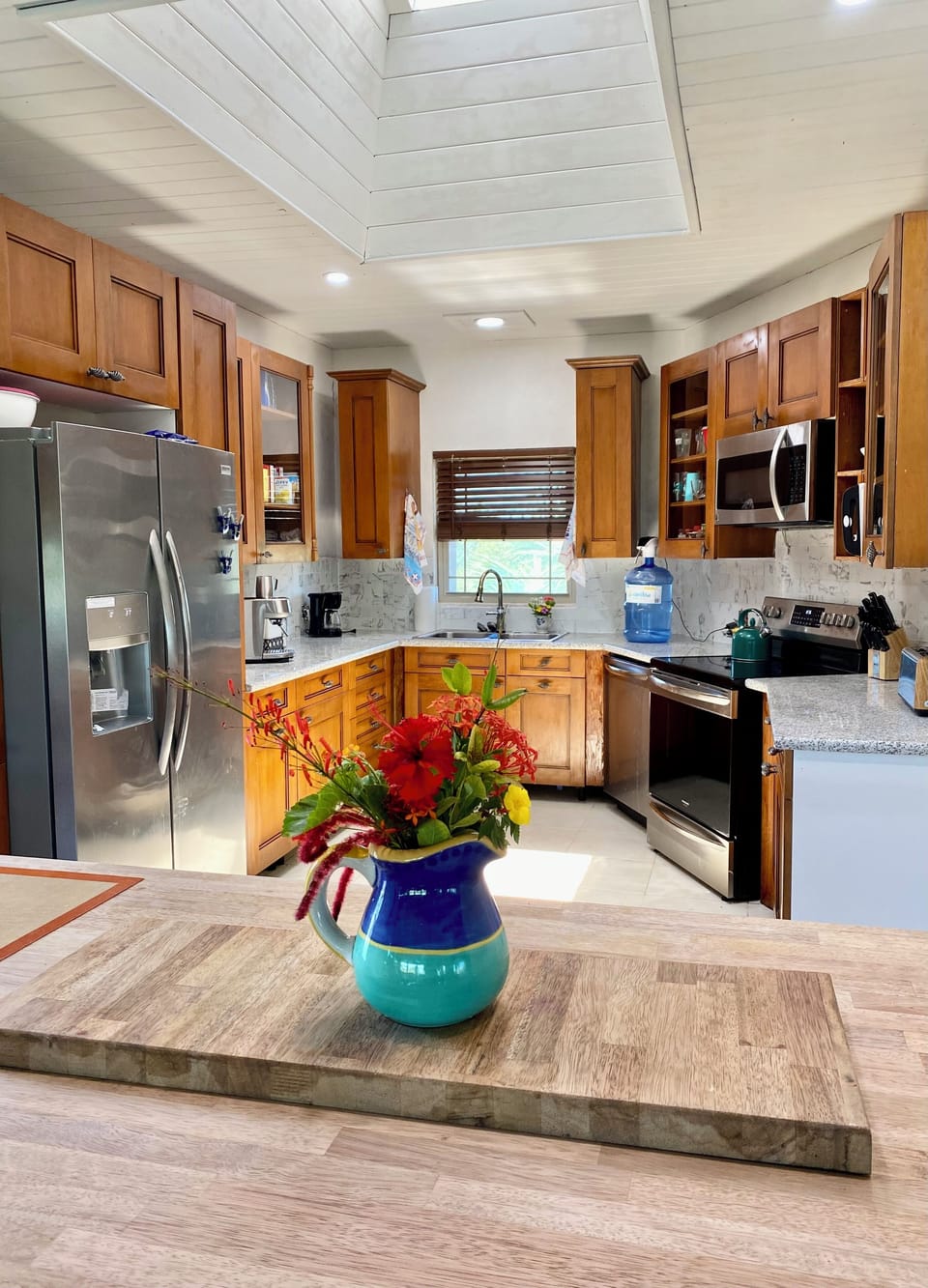 Kitchen has assortment of small appliances and a countertop ice machine. 