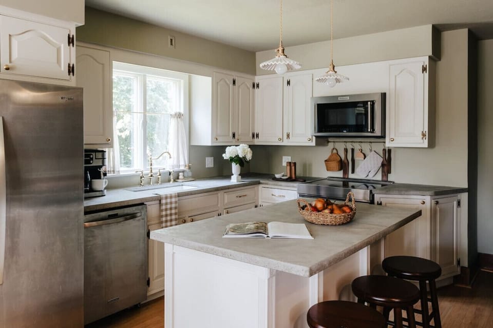 A fully equipped kitchen with stainless steel appliances, a spacious island, and charming farmhouse details.