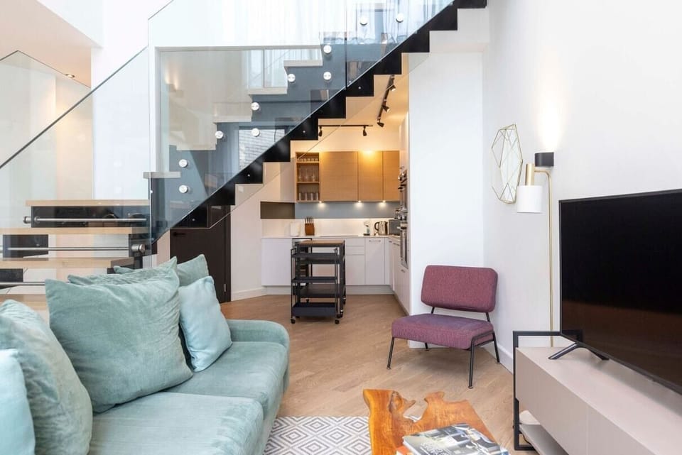 Spacious open-plan living room and fully equipped kitchen area with a dining table, offering access to a private, furnished patio.