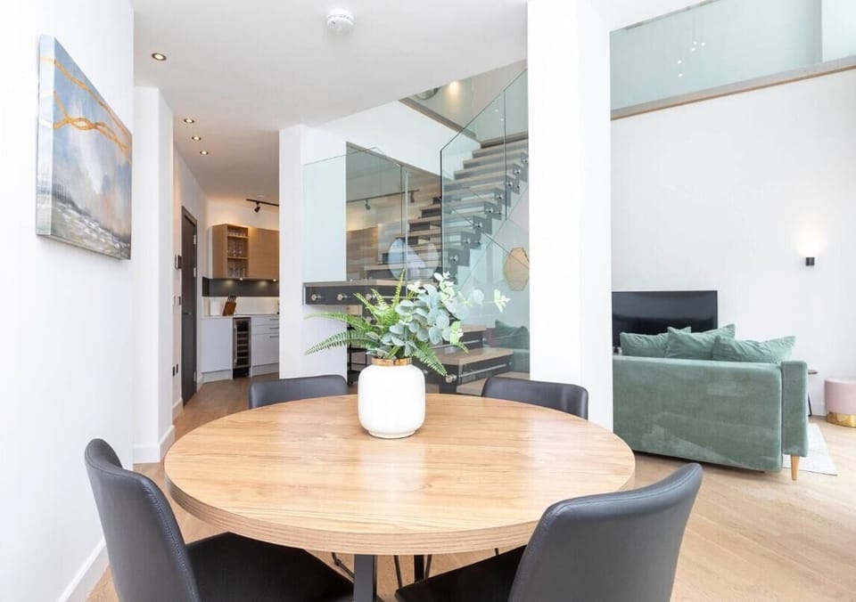 Spacious open-plan living room and fully equipped kitchen area with a dining table, offering access to a private, furnished patio.