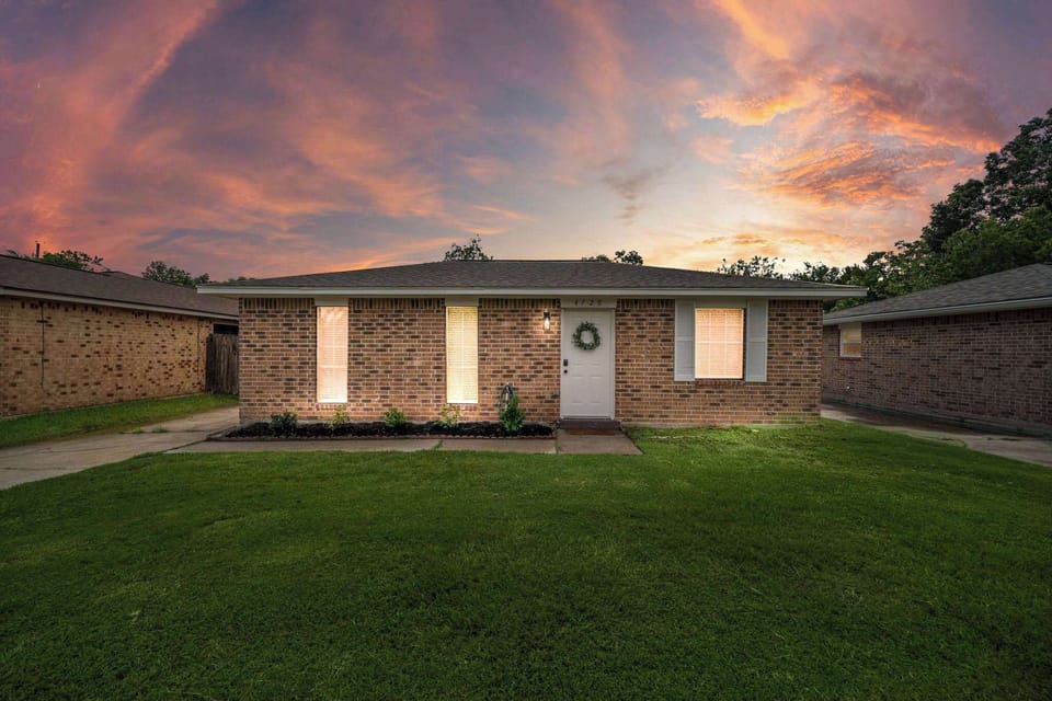 Charming Exterior: Bright and inviting home with vibrant sunset views and lush green lawn!