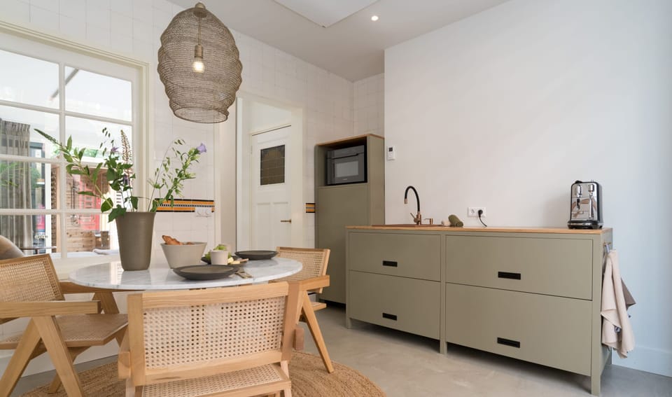 Stylish kitchen and dining area with warm wood details and natural light — perfect for enjoying a slow breakfast or sharing a meal together.