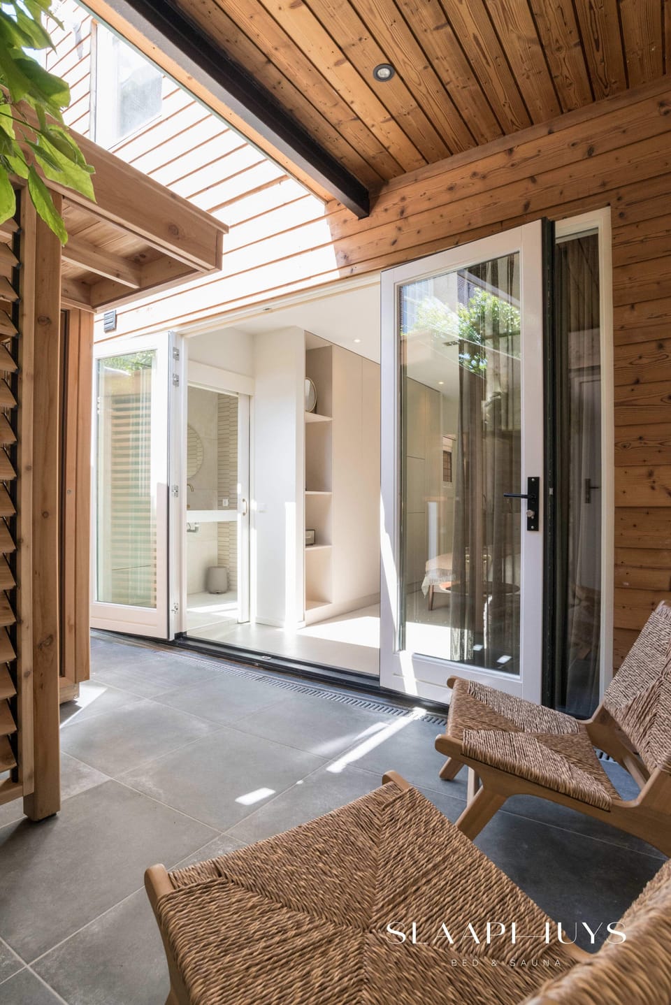 Covered patio with natural wood accents and relaxing lounge chairs.