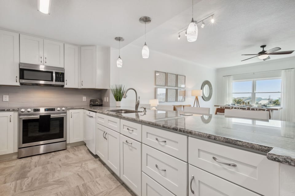 Open Concept Floor Plan with Sparkling White Kitchen Overlooking Living and Dining Spaces