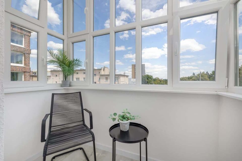 A sunny balcony corner with a small table and two chairs. Perfect for morning coffee with a view of the city.