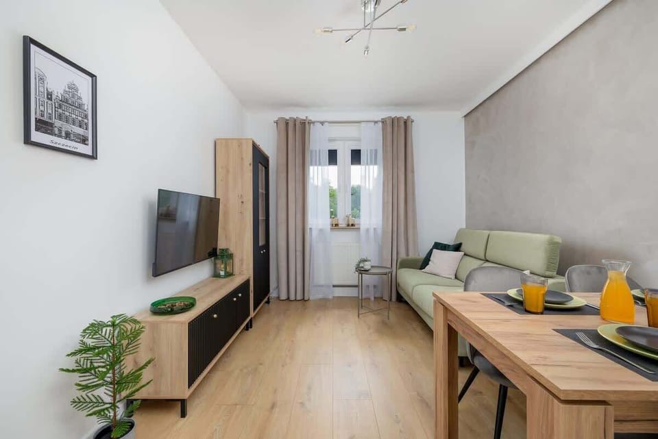 A living area with a round dining table set for two, accented with plants and natural textures. A calming and inviting spot to dine or relax.