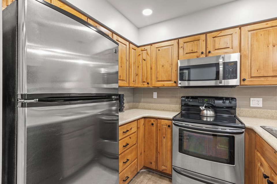 The kitchen has wood cabinets and stainless steel appliances.