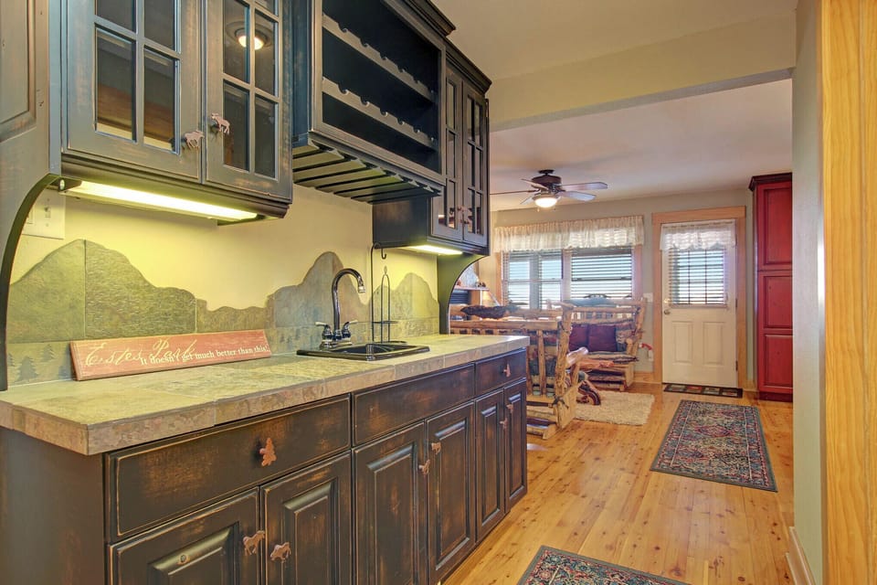 Wet bar with beautiful mountain themed backsplash. Adjacent to kitchen/dining area.