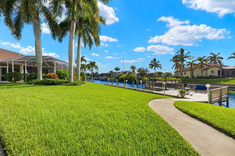 The spacious backyard lawn leads right down to the canal, with a paver path connecting it all.