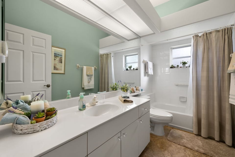 The guest bathroom offers a bright, clean shower/tub combo for easy mornings.