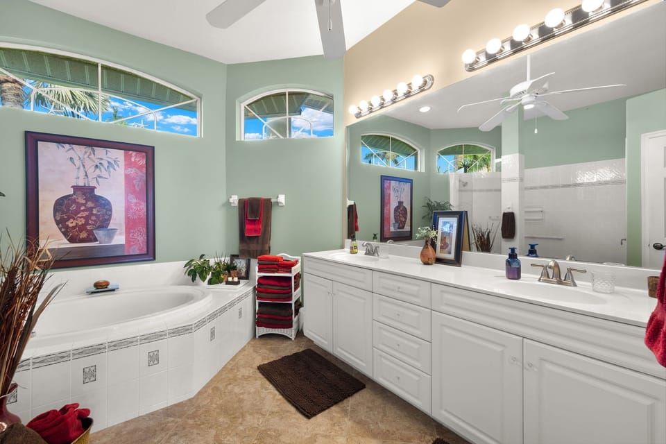 Dual sinks and bright arched windows make getting ready easy in the primary bathroom.