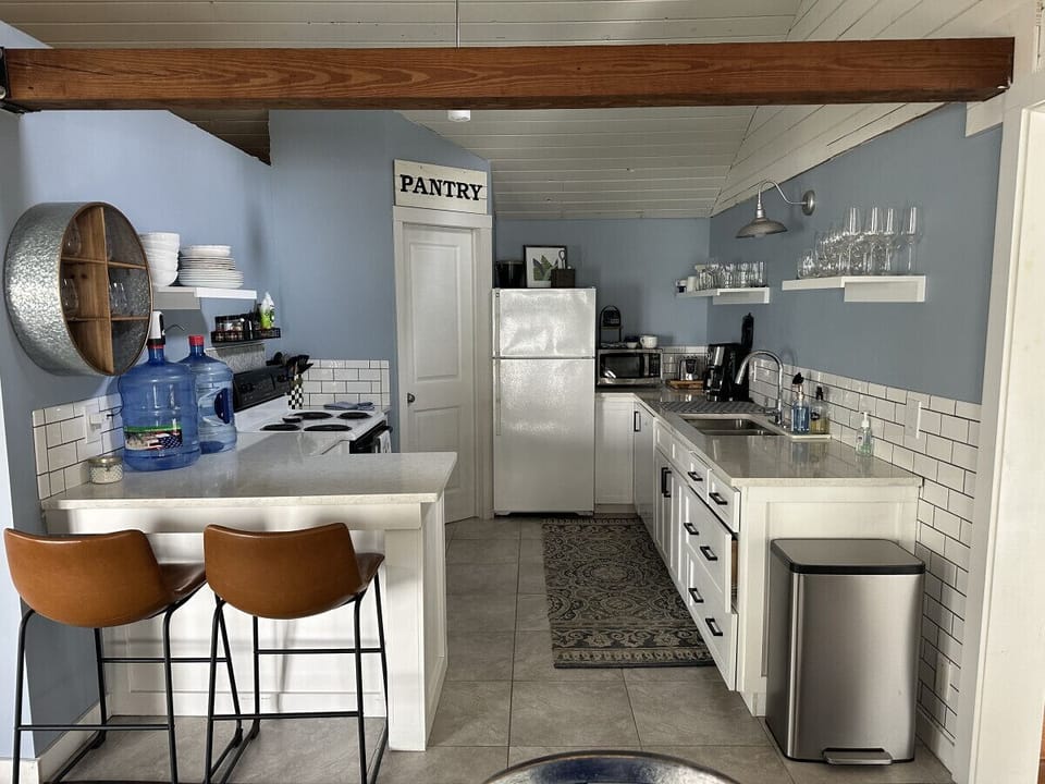 Highlights include seating for 6, a Keurig coffee machine with provided pods, a dishwasher, complimentary pure spring water dispenser, a microwave, a toaster oven, and plenty of various baking dishes, utensils, and spices.