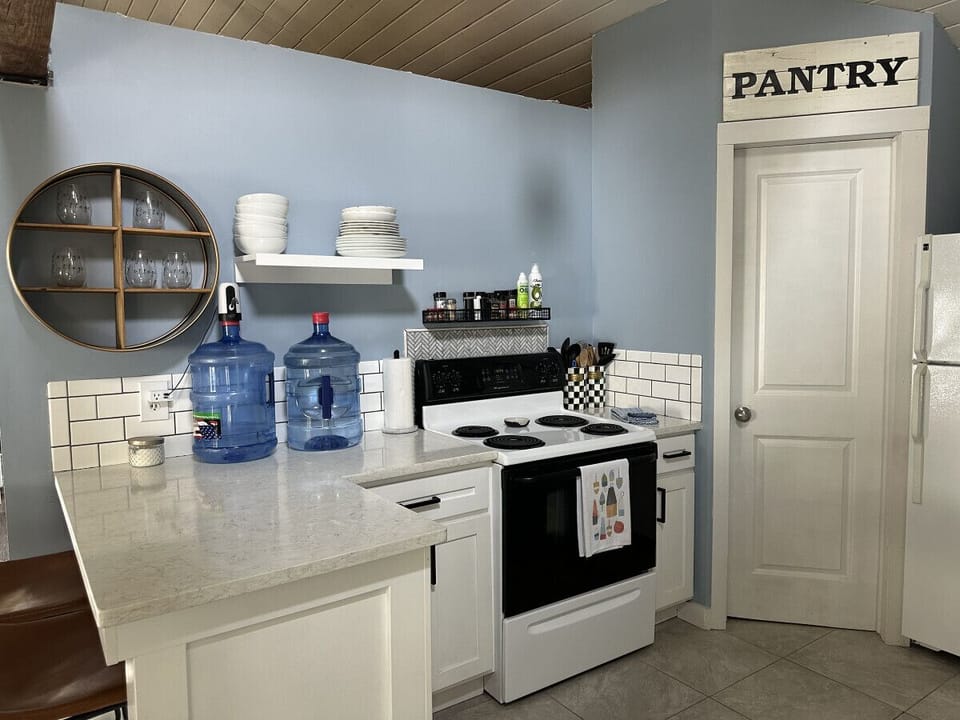 Kitchen highlights include seating for 6, a Keurig coffee machine with provided pods, a dishwasher, complimentary pure spring water dispenser, a microwave, a toaster oven, and plenty of various baking dishes, utensils, and spices.