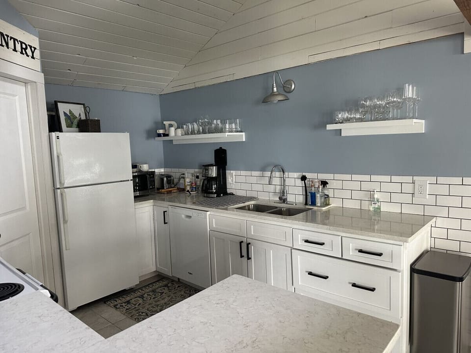 Kitchen highlights include seating for 6, a Keurig coffee machine with provided pods, a dishwasher, complimentary pure spring water dispenser, a microwave, a toaster oven, and plenty of various baking dishes, utensils, and spices.
