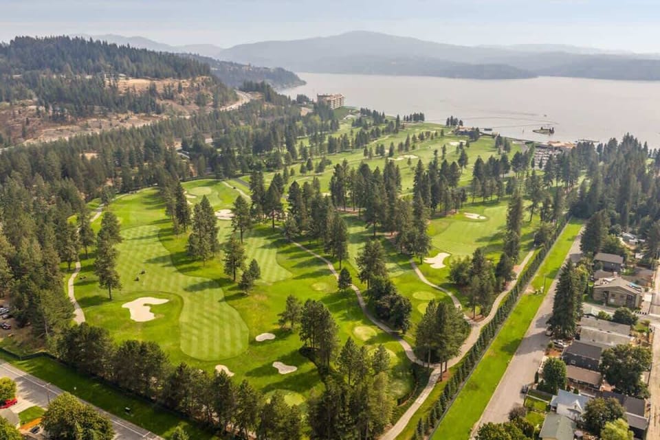 Scenic greens surrounded by mountains and the lake.