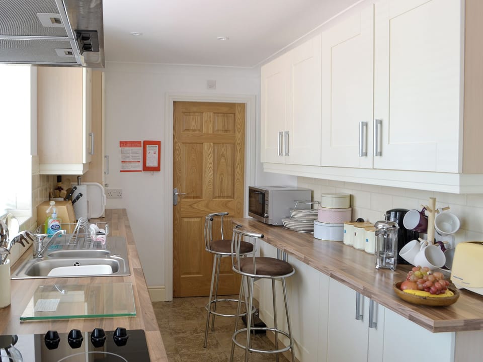 Galley-style kitchen with breakfast bar | Barkers Cottage, Ellington, near Druridge
