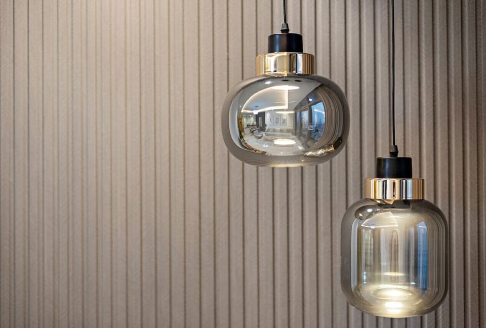 Lighting Elegance: Sleek pendant lights twinkle against textured walls for a chic ambiance!