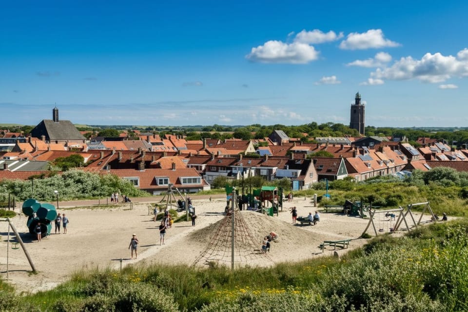 Beautiful panorama of rooftops, church tower and sunny park area.