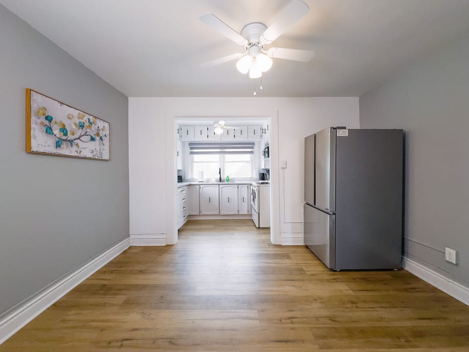 A Bright And Spacious Dining Area Leading Into A Modern Kitchen