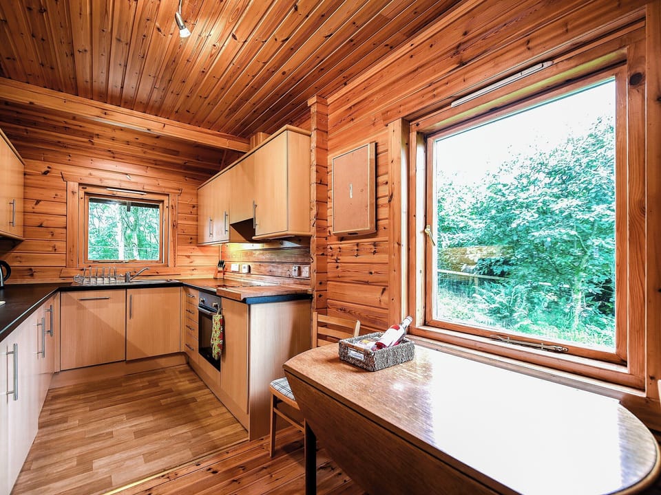 Charming kitchen with dining area overlooking the garden | Criffel Lodge, Tongland, Kirkcudbright