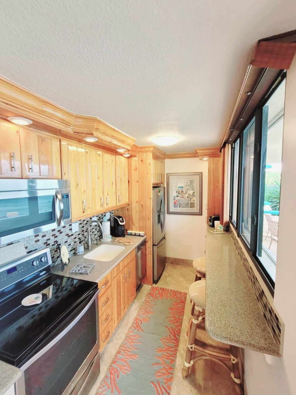 Custom kitchen with stainless steel appliances, oceanview counter, nice lighting