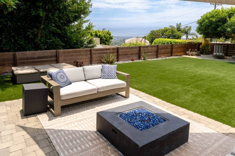 Outdoor lounge area with fire pit overlooking the backyard.