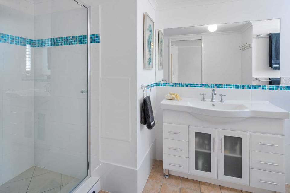 The main bathroom offers a vanity, small bath, shower and a separate toilet.