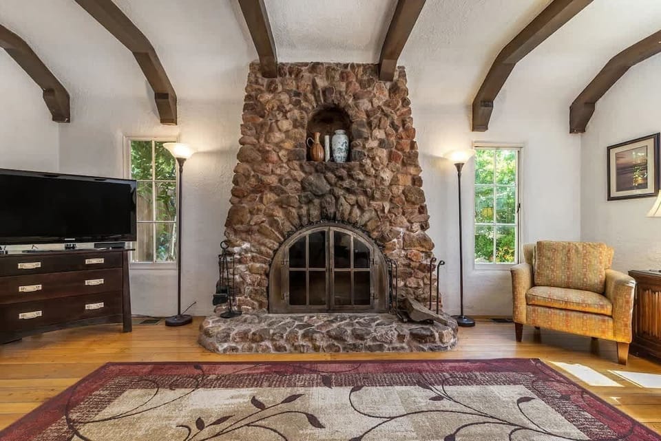 The majestic fireplace serves as the centerpiece of the living room, creating a warm and inviting atmosphere, with the TV tucked neatly in the corner for added entertainment.