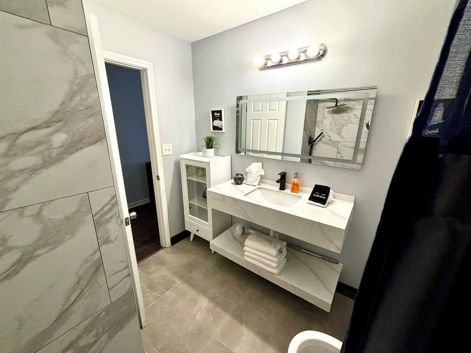 Elegant Bathroom: Modern fixtures, sleek marble surfaces, and ambient lighting await your retreat!