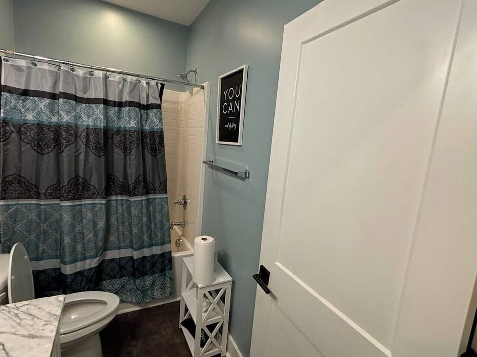 Bathroom Oasis: Stylish decor, elegant marble countertop, and vibrant patterned shower curtain await!