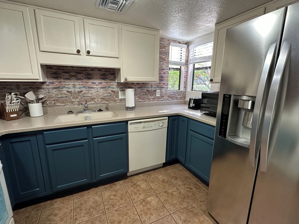 Fully stocked kitchen updated with corian counters and full size appliances