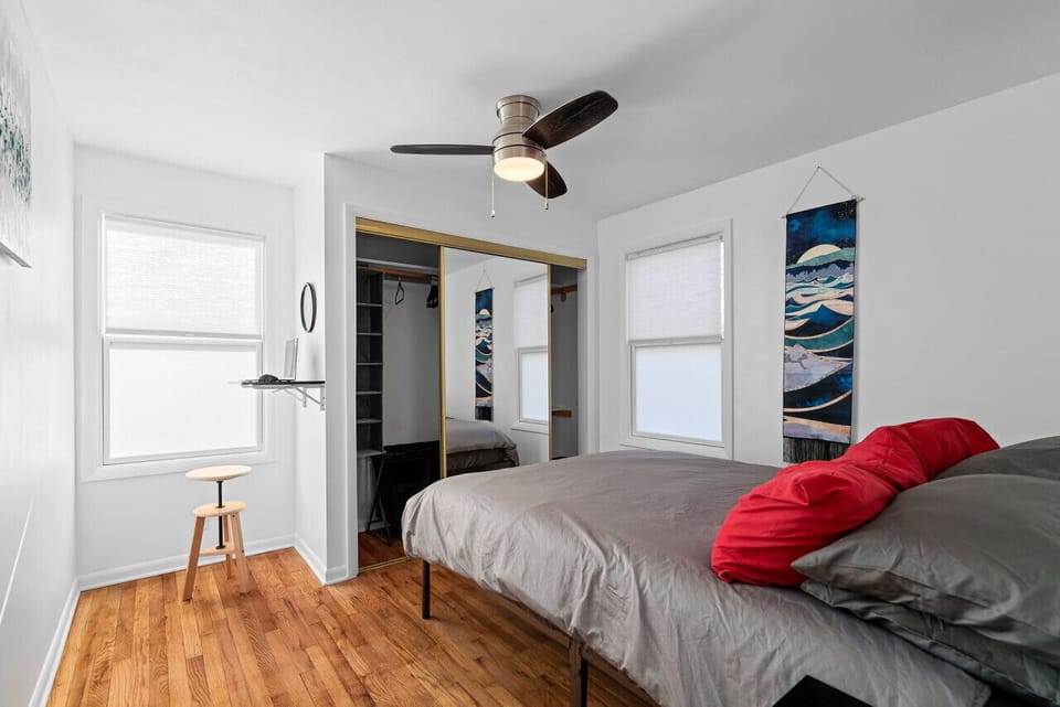 Modern bedroom with bold red accents and a comfy bed.