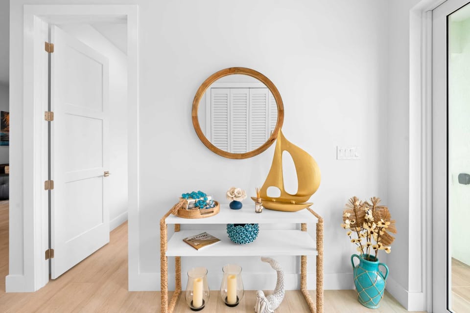 Transform your space with a touch of elegance! This living room features a sleek table and a glamorous mirror.