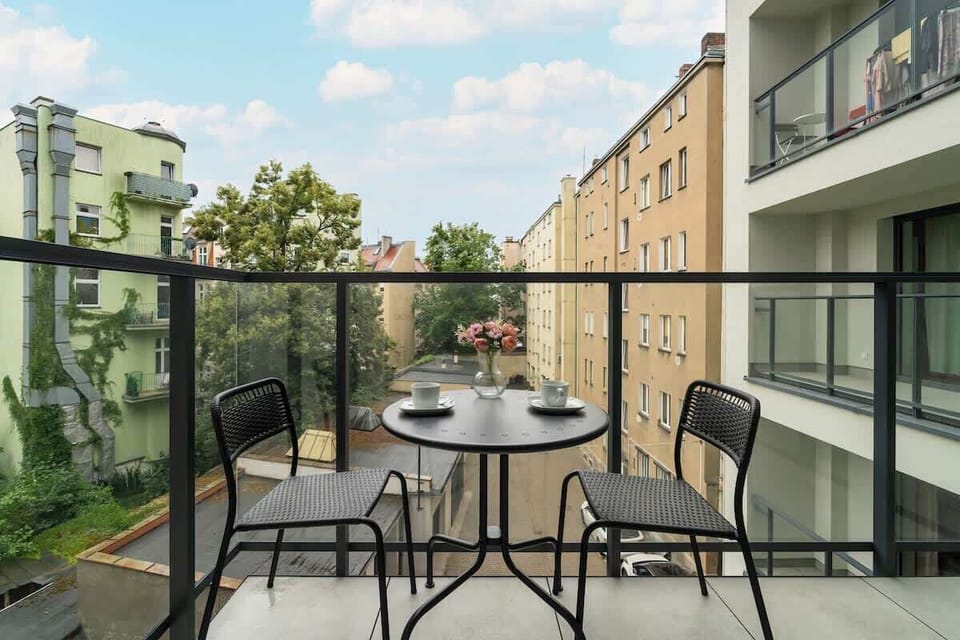 A large balcony with lounge chairs and a peaceful courtyard view. A great spot for outdoor relaxation.