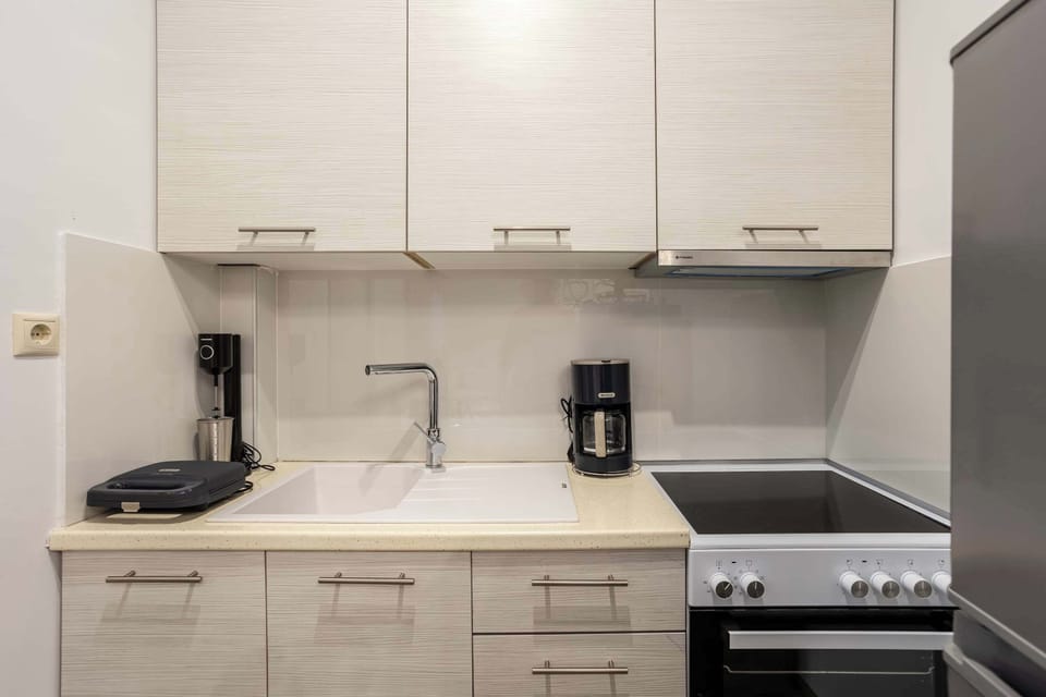 Sleek White Kitchen with Modern Cabinets and Small Appliances

