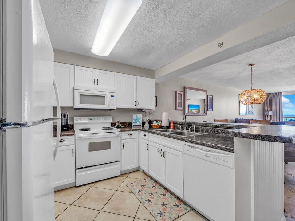 Your fully equipped kitchen features granite counters, white appliances, and everything needed to create memorable meals during your stay.