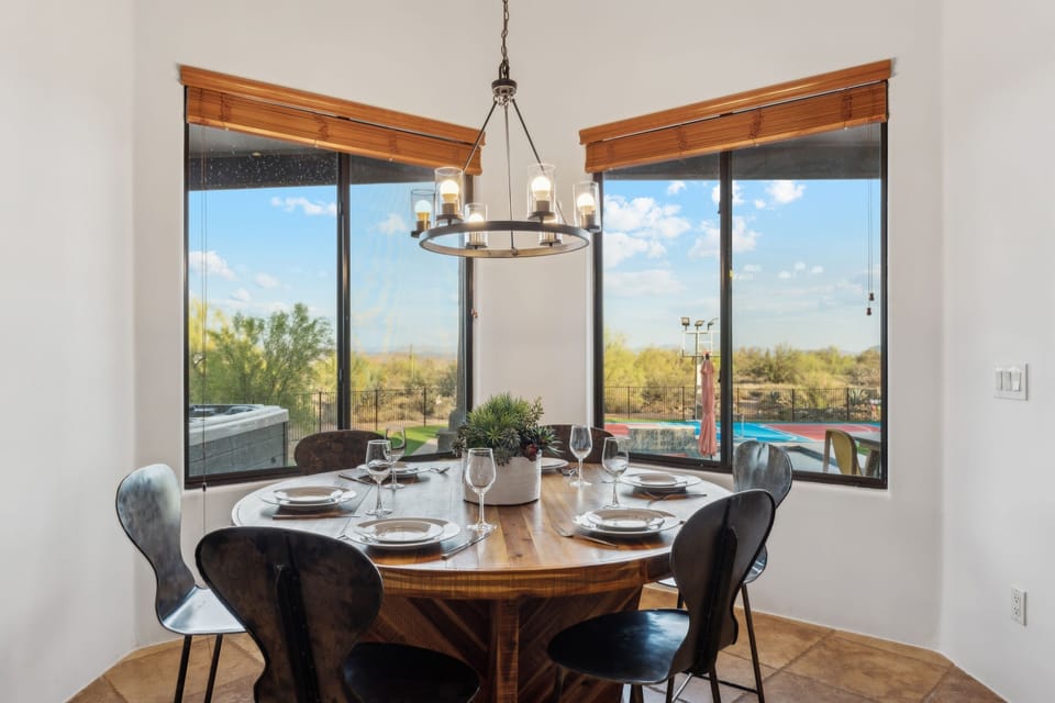 Cozy dining nook for six with panoramic views of the pool and desert—perfect for sunny breakfasts or evening meals. | The Sonoran, Scottsdale, Arizona | Voyax Luxury Vacation Rentals