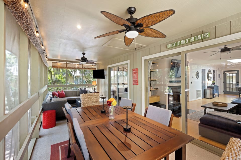 Screened porch with table and chairs, seating, and TV