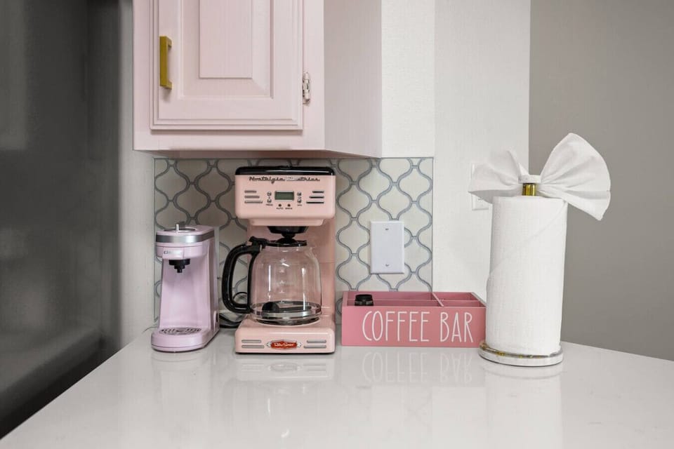 ☕✨ Start your day in style at this adorable pink coffee bar! Brew your favorite cup, snap a cute pic, and fuel up for adventures—because coffee tastes better when it’s this chic.