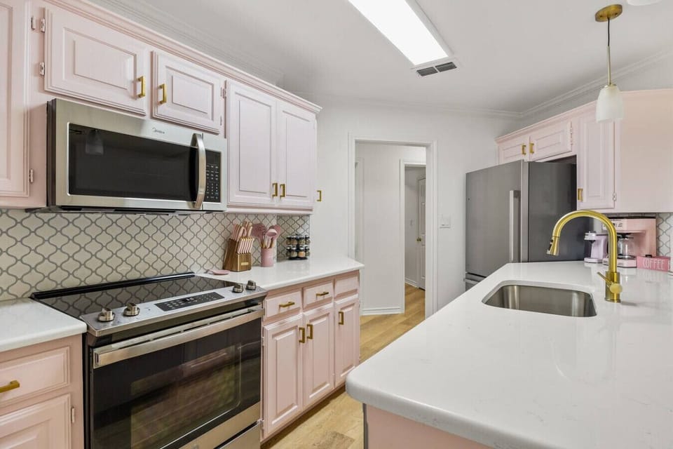 Step into a pastel dream—this chic pink kitchen is equal parts stylish and functional. With gold accents, modern appliances, and a coffee bar ready for your morning pick-me-up, it’s the perfect spot to cook, sip, or snap the prettiest photos.