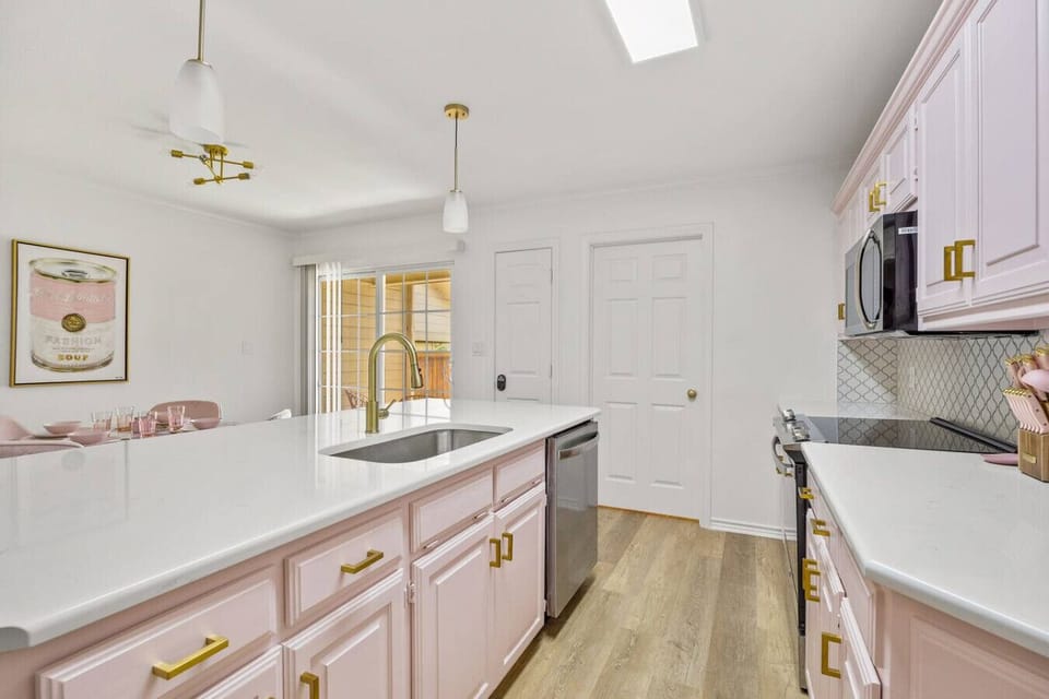 This kitchen serves looks and delicious meals—pink cabinets, gold fixtures, and sleek appliances set the scene. Whether you’re brewing coffee, mixing cocktails, or baking with friends, you’ll love the playful elegance of this space.