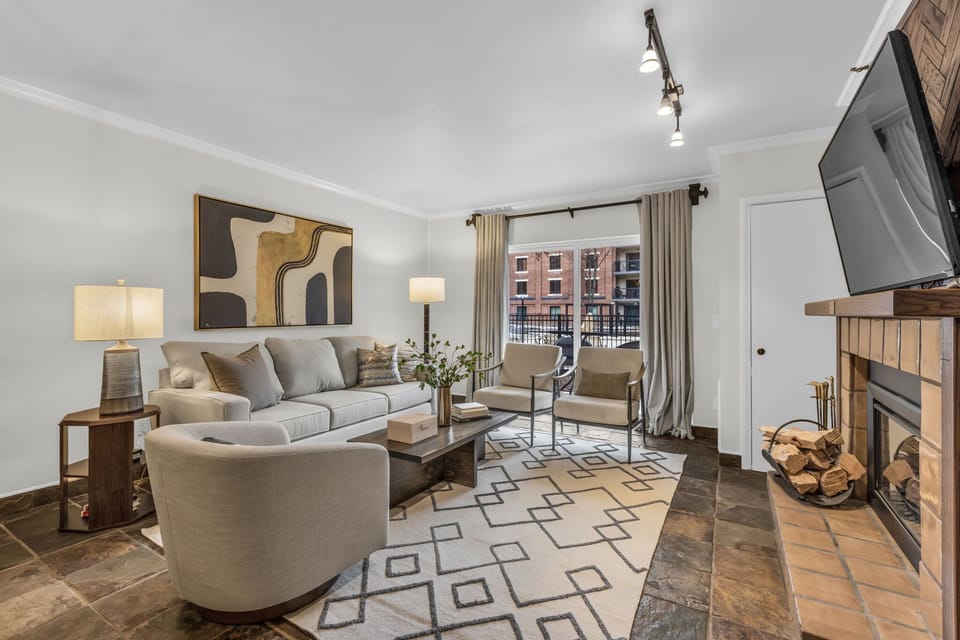 Living Room: 55” TV, wood burning fireplace, access to patio