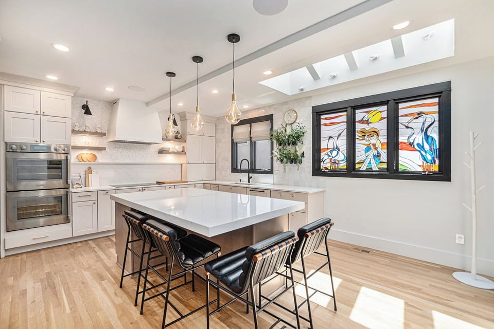 - Enjoy this chef inspired kitchen with quartz counters, pendant lights, and top tier appliances
- Island seating for four makes it ideal for morning coffee or casual meals
- Artistic stained glass window adds a vibrant personal touch