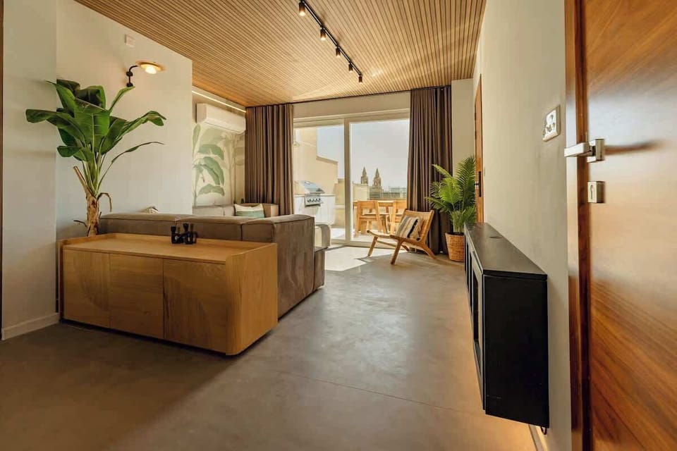 Living room connected with open kitchen, with direct access to the patio with outdoor dining (equipped with BBQ), sun beds and private pool.